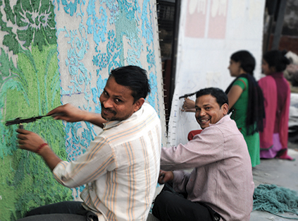 artigiani indiani che tessono tappeti a mano